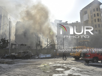 Firefighters extinguish the blaze at the site of overnight Israeli airstrikes that target the neighborhood of Kafaat in Beirut's southern su...