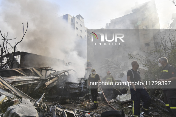 Firefighters extinguish the blaze at the site of overnight Israeli airstrikes that target the neighborhood of Kafaat in Beirut's southern su...