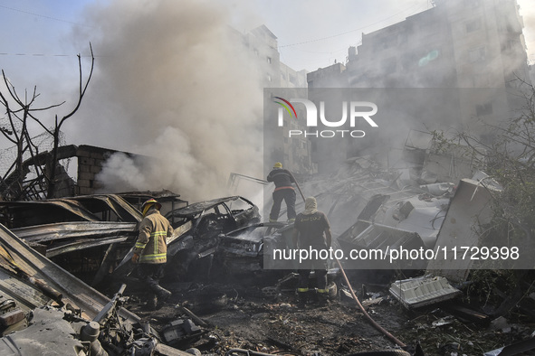 Firefighters extinguish the blaze at the site of overnight Israeli airstrikes that target the neighborhood of Kafaat in Beirut's southern su...