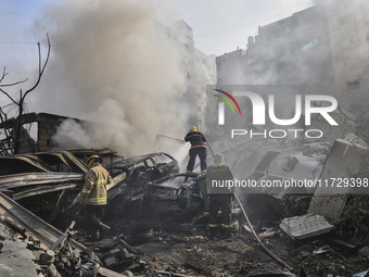 Firefighters extinguish the blaze at the site of overnight Israeli airstrikes that target the neighborhood of Kafaat in Beirut's southern su...