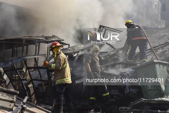 Firefighters extinguish the blaze at the site of overnight Israeli airstrikes that target the neighborhood of Kafaat in Beirut's southern su...