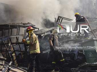 Firefighters extinguish the blaze at the site of overnight Israeli airstrikes that target the neighborhood of Kafaat in Beirut's southern su...