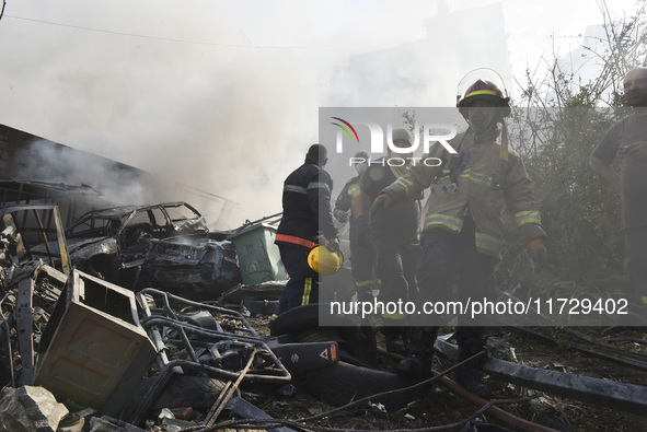 Firefighters extinguish the blaze at the site of overnight Israeli airstrikes that target the neighborhood of Kafaat in Beirut's southern su...