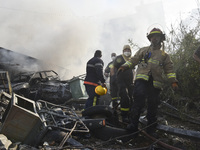 Firefighters extinguish the blaze at the site of overnight Israeli airstrikes that target the neighborhood of Kafaat in Beirut's southern su...