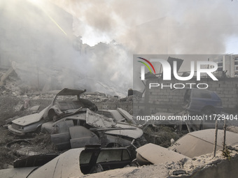 Firefighters extinguish the blaze at the site of overnight Israeli airstrikes that target the neighborhood of Kafaat in Beirut's southern su...