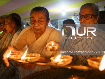 Elderly women at Pramod Talukdar Memorial Old Age Home light Diya oil lamps as they celebrate Diwali in Guwahati, India, on November 1, 2024...