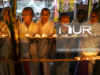 Elderly women at Pramod Talukdar Memorial Old Age Home light Diya oil lamps as they celebrate Diwali in Guwahati, India, on November 1, 2024...