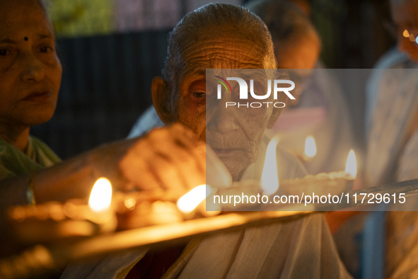 Elderly women at Pramod Talukdar Memorial Old Age Home light Diya oil lamps as they celebrate Diwali in Guwahati, India, on November 1, 2024...