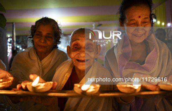 Elderly women at Pramod Talukdar Memorial Old Age Home light Diya oil lamps as they celebrate Diwali in Guwahati, India, on November 1, 2024...