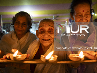 Elderly women at Pramod Talukdar Memorial Old Age Home light Diya oil lamps as they celebrate Diwali in Guwahati, India, on November 1, 2024...