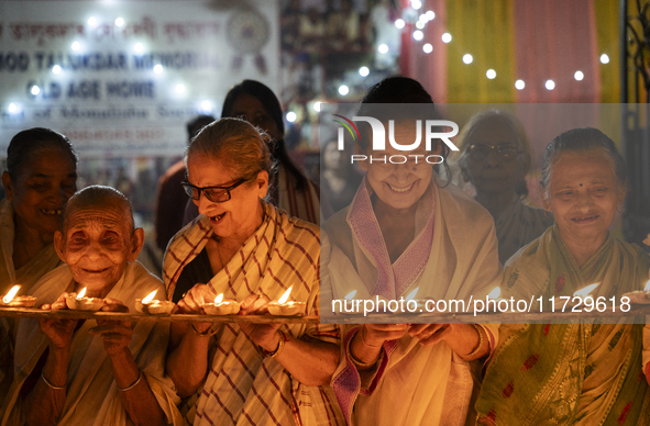 Elderly women at Pramod Talukdar Memorial Old Age Home light Diya oil lamps as they celebrate Diwali in Guwahati, India, on November 1, 2024...