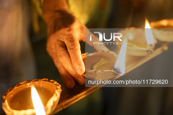 Elderly women at Pramod Talukdar Memorial Old Age Home light Diya oil lamps as they celebrate Diwali in Guwahati, India, on November 1, 2024...