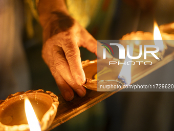 Elderly women at Pramod Talukdar Memorial Old Age Home light Diya oil lamps as they celebrate Diwali in Guwahati, India, on November 1, 2024...