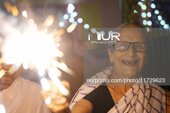 An elderly woman at Pramod Talukdar Memorial Old Age Home burns sparkler crackers as she celebrates Diwali in Guwahati, India, on November 1...