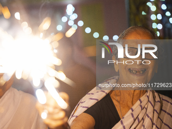 An elderly woman at Pramod Talukdar Memorial Old Age Home burns sparkler crackers as she celebrates Diwali in Guwahati, India, on November 1...