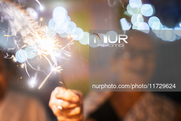 An elderly woman at Pramod Talukdar Memorial Old Age Home burns sparkler crackers as she celebrates Diwali in Guwahati, India, on November 1...