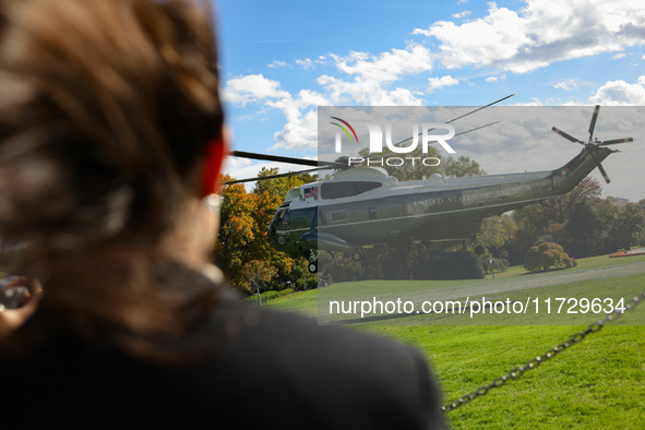 Seen beyond a member of the press, Marine One carrying U.S. President Joe Biden departs the South Lawn of the White House in Washington, D.C...