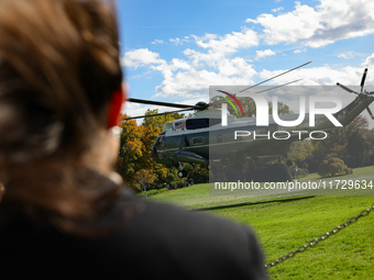 Seen beyond a member of the press, Marine One carrying U.S. President Joe Biden departs the South Lawn of the White House in Washington, D.C...