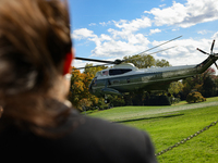 Seen beyond a member of the press, Marine One carrying U.S. President Joe Biden departs the South Lawn of the White House in Washington, D.C...