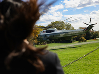 Seen beyond a member of the press, Marine One carrying U.S. President Joe Biden departs the South Lawn of the White House in Washington, D.C...