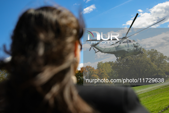 Seen beyond a member of the press, Marine One carrying U.S. President Joe Biden departs the South Lawn of the White House in Washington, D.C...