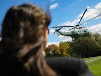 Seen beyond a member of the press, Marine One carrying U.S. President Joe Biden departs the South Lawn of the White House in Washington, D.C...