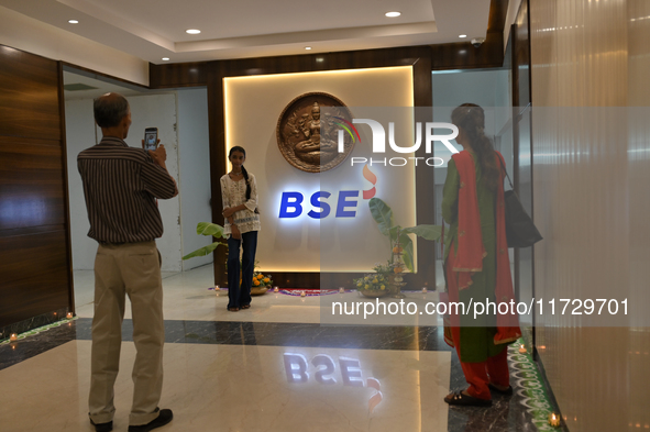 A girl poses in front of the BSE (Bombay Stock Exchange) logo during a special ''muhurat'' trading session for Diwali, the Hindu festival of...