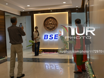 A girl poses in front of the BSE (Bombay Stock Exchange) logo during a special ''muhurat'' trading session for Diwali, the Hindu festival of...