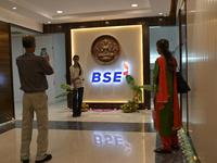 A girl poses in front of the BSE (Bombay Stock Exchange) logo during a special ''muhurat'' trading session for Diwali, the Hindu festival of...