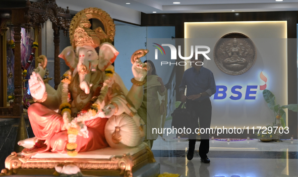 People walk past a BSE (Bombay Stock Exchange) logo during a special ''muhurat'' trading session for Diwali, the Hindu festival of lights, a...