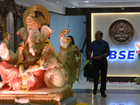 People walk past a BSE (Bombay Stock Exchange) logo during a special ''muhurat'' trading session for Diwali, the Hindu festival of lights, a...