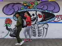 Residents of Santiago Zapotitlan, Tlahuac, walk in front of a mural in Mexico City, Mexico, on November 1, 2024, as they head to the communi...