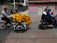 Residents of Santiago Zapotitlan in Mexico City, Mexico, on November 1, 2024, transport flowers on a tricycle to the community cemetery wher...