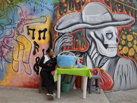 A mural is visible in Santiago Zapotitlan in Mexico City, on November 1, 2024, where inhabitants attend the community cemetery to decorate t...