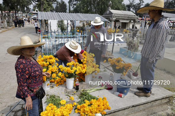 Residents of Santiago Zapotitlan in Mexico City, Mexico, on November 1, 2024, attend the old cemetery to decorate the graves of their deceas...