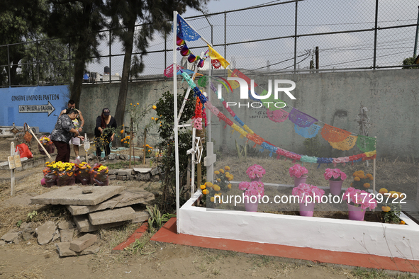 Residents of Santiago Zapotitlan in Mexico City, Mexico, on November 1, 2024, attend the old cemetery to decorate the graves of their deceas...