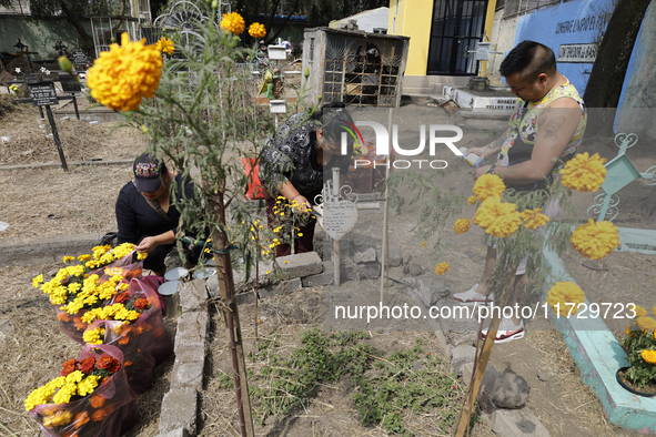 Residents of Santiago Zapotitlan in Mexico City, Mexico, on November 1, 2024, attend the old cemetery to decorate the graves of their deceas...