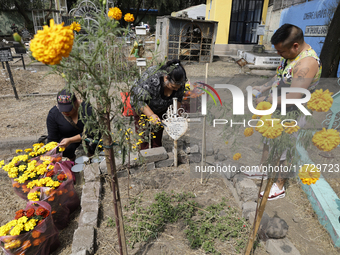 Residents of Santiago Zapotitlan in Mexico City, Mexico, on November 1, 2024, attend the old cemetery to decorate the graves of their deceas...