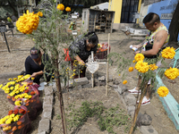 Residents of Santiago Zapotitlan in Mexico City, Mexico, on November 1, 2024, attend the old cemetery to decorate the graves of their deceas...