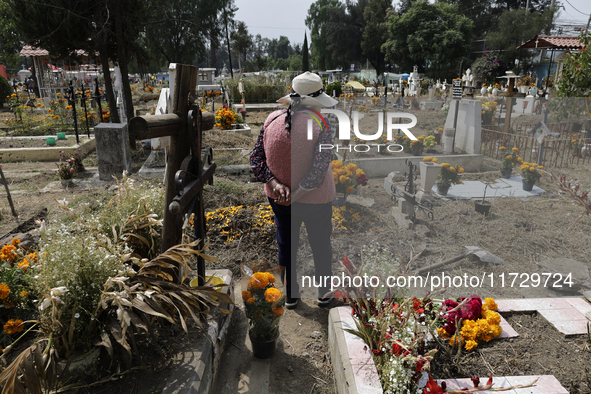 Residents of Santiago Zapotitlan in Mexico City, Mexico, on November 1, 2024, attend the old cemetery to decorate the graves of their deceas...