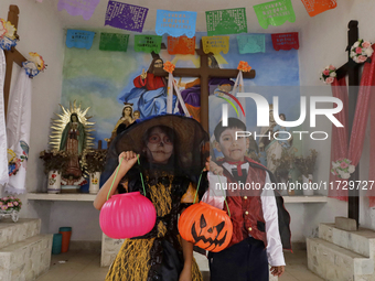 A girl and a boy dress up inside a chapel in the old Santiago Zapotitlan cemetery in Mexico City, Mexico, on November 1, 2024, where dozens...