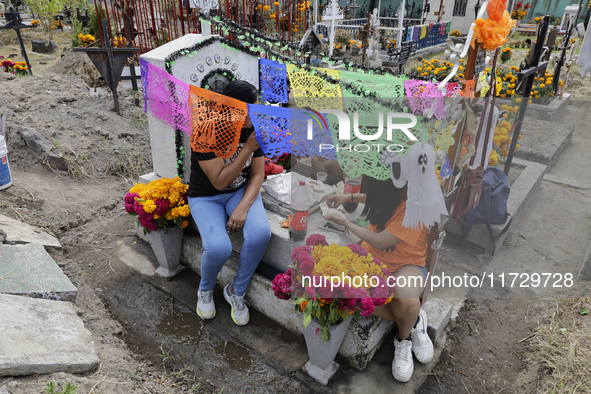 Residents of Santiago Zapotitlan in Mexico City, Mexico, on November 1, 2024, attend the old cemetery to decorate the graves of their deceas...