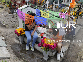 Residents of Santiago Zapotitlan in Mexico City, Mexico, on November 1, 2024, attend the old cemetery to decorate the graves of their deceas...