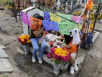 Residents of Santiago Zapotitlan in Mexico City, Mexico, on November 1, 2024, attend the old cemetery to decorate the graves of their deceas...