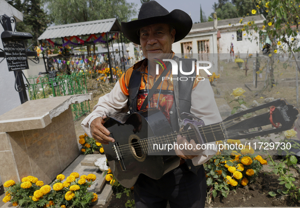 Musicians from Santiago Zapotitlan in Mexico City, Mexico, attend the old cemetery on November 1, 2024, to decorate the graves of their dece...