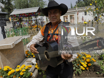 Musicians from Santiago Zapotitlan in Mexico City, Mexico, attend the old cemetery on November 1, 2024, to decorate the graves of their dece...