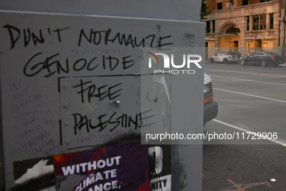 Seen beyond graffiti on a utility box near the White House, storefronts are covered by plywood in Washington, D.C. on November 1, 2024 in pr...