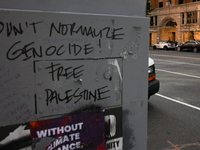 Seen beyond graffiti on a utility box near the White House, storefronts are covered by plywood in Washington, D.C. on November 1, 2024 in pr...