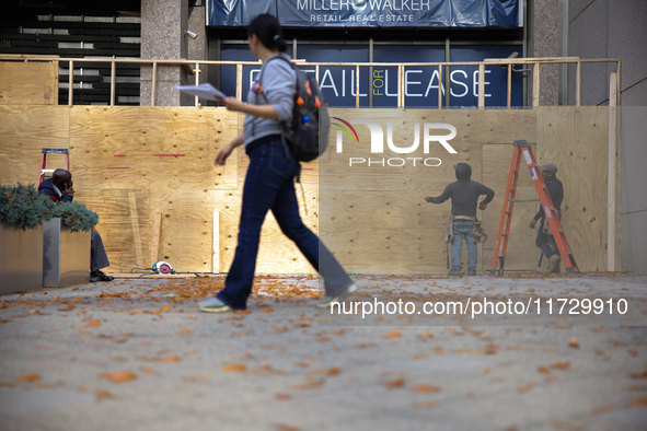 A person walks past boarded up storefronts near the White House in Washington, D.C. on November 1, 2024 as local busineses prepare for possi...