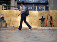 A person walks past boarded up storefronts near the White House in Washington, D.C. on November 1, 2024 as local busineses prepare for possi...